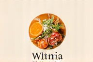 Ręce trzymające kiełki rośliny, symbolizujące wzrost i naturalne zdrowie, z delikatnym, rozproszonym światłem w tle.